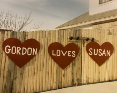 In giant hearts on the fence, it says Gordon Loves Susan