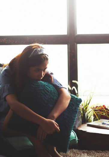 Young girl holding pillow out of sadness
