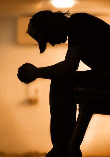 Young man in the shadow, leaning over