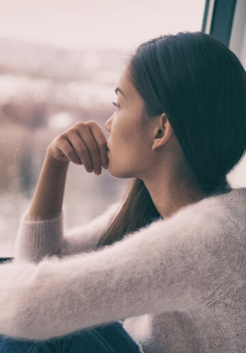 Woman looking out the window, sadly